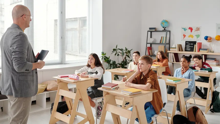 A teacher conducting a lesson in a diverse, engaging classroom with attentive students.